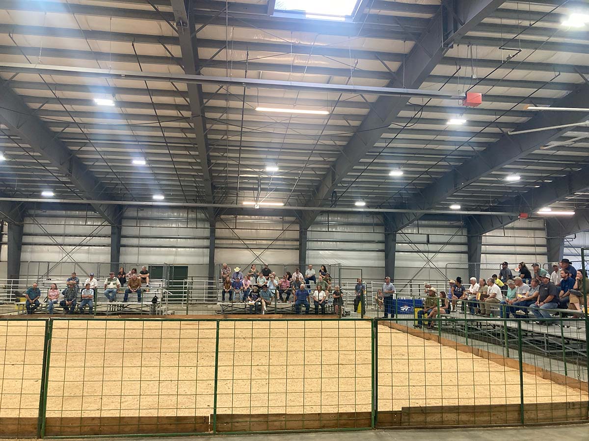 A Montana Farmers Union event at an indoor livestock facility with bleachers.